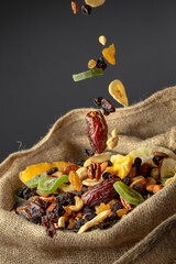 Dried tropical fruits and nuts in burlap bag.