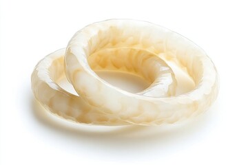 Two cream-colored bangles with ornate carvings, isolated on white.