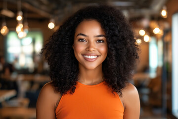 Obraz premium Bright and joyful black woman with afro hair smiles warmly in in the office afternoon