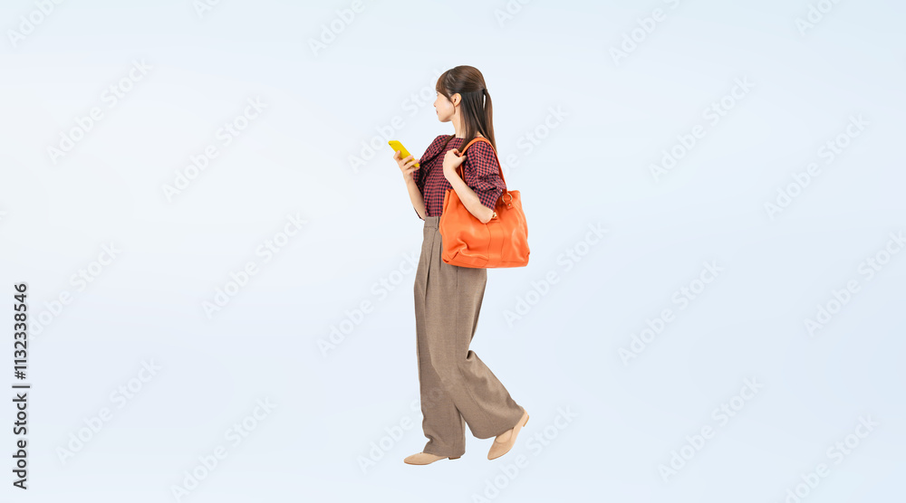 Aufkleber スマホを持って歩くカジュアルウェアの女性の全身写真