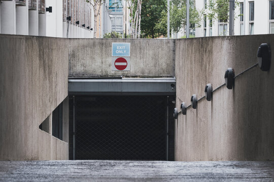 A stark visual of an exit-only sign and tunnel entrance, portraying a moment of urban life and the structured design of city spaces and their significance to movement.
