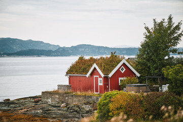 Red wooden house with orange tiled roof on overcast day