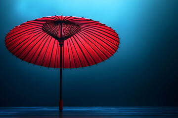 Crimson Parasol, A Dramatic Still Life Image of an Elegant Red Umbrella Against a Deep Blue Background
