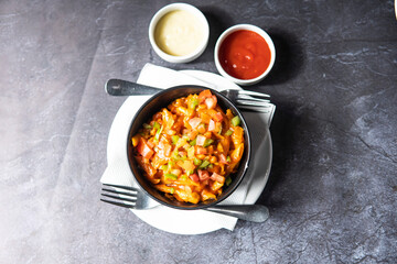 Red Chili and tomato Pasta with ketchup, mayo dip and fork served in bowl dish isolate on grey...