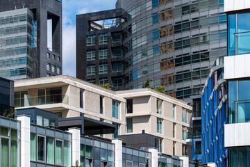 A collage of sleek, modern mixed-use buildings featuring glass facades and unique designs, highlighting the integration of living and working spaces in a vibrant urban setting in Amsterdam