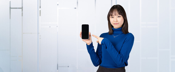 スマホを指差す女性・ビジネスウーマン