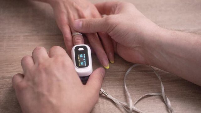 Close-up of a pulse oximeter measuring oxygen levels on a person's finger, showcasing health monitoring and medical technology. Concept of health check, self-care