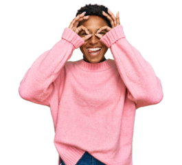 Young african american woman wearing casual clothes doing ok gesture like binoculars sticking tongue out, eyes looking through fingers. crazy expression.