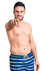 Fototapeta premium Young handsome man wearing swimwear pointing displeased and frustrated to the camera, angry and furious with you