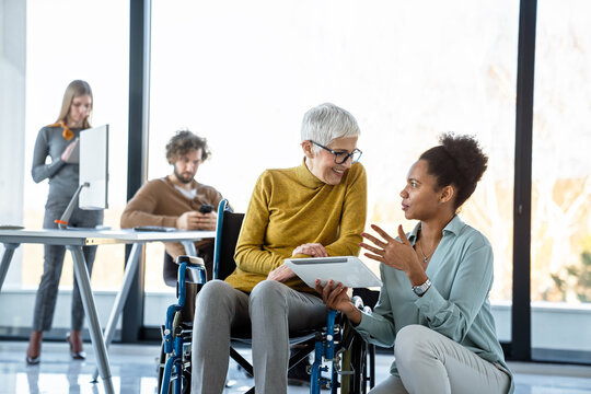 A diverse group of young professionals, including senior businesswomen entrepreneur in a wheelchair - Powered by Adobe