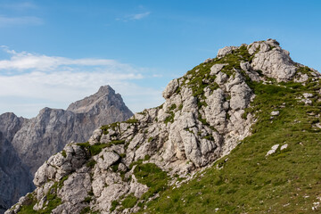 Hiking trail with scenic view of rugged mountain peak Razor in Julian Alps seen from Triglav...