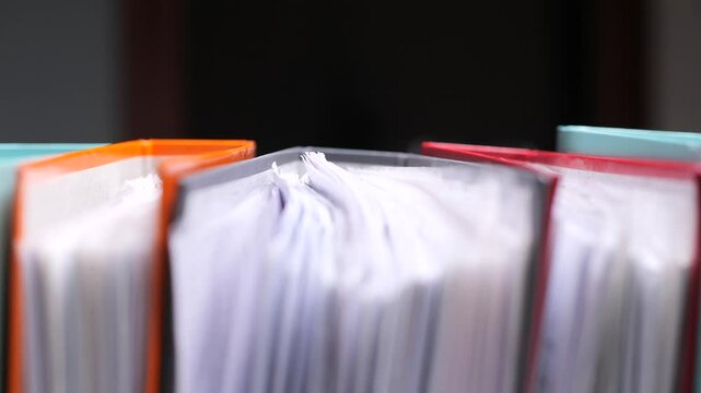 Colorful binders full of paperwork representing office work and organization