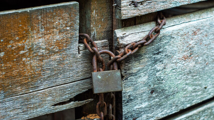 Rusty Padlock and Chain on a Wooden Door