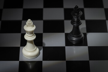 A close-up of a chessboard highlighting the white KING standing out among black pieces, symbolizing...