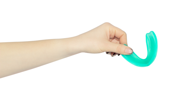 sports mouthguard for teeth in hand, outstretched hand with mouthguard isolated from background