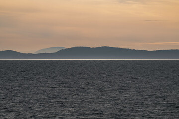 Fototapeta premium Vancouver island coastline during sunset, view from a ferry on the water