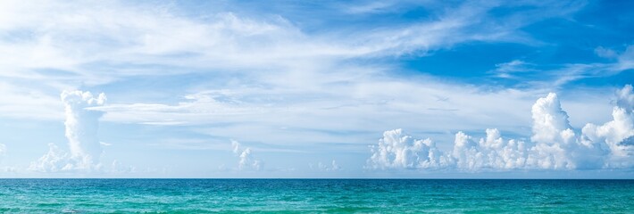 Obraz premium Panoramic beautiful seascape with blue sky on a sunny day. Nature background. Sea surface in sun light. Relaxing natural photo wallpaper. Teal blue ocean view. Breezy wavy seawater.