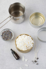 Soy vox in bulk, in a metal container, wicks, aroma oil, lavender on a light background. Making handmade candles.