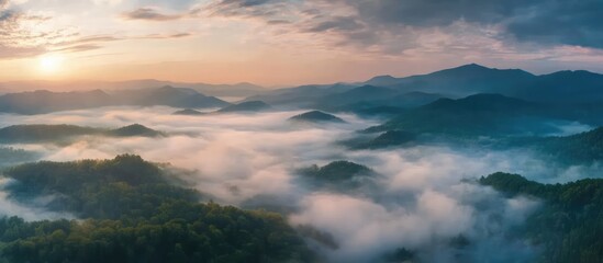 Panoramic view of a foggy landscape at sunset with vibrant fireworks illuminating the sky during a festive celebration event