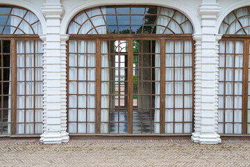 View of the facade of a building with a long corridor-gallery with windows and columns