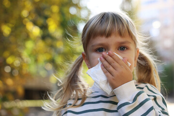 Little girl with runny nose in park