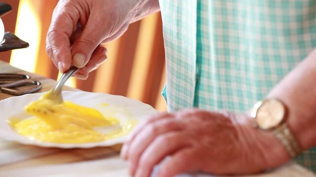 hand beating eggs on a plate, domestic kitchen