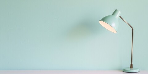 A minimalist desk lamp stands against a soft mint green wall, creating a serene and stylish ambiance in the room.