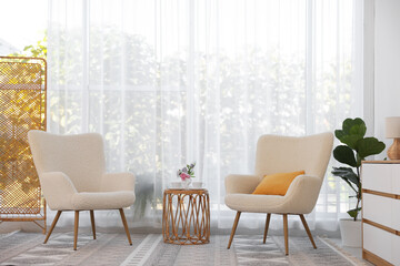 Stylish living room interior with soft white armchairs