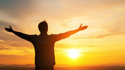 Man raising arms in gratitude at sunset, embracing freedom and connecting deeply with the beauty of nature in a serene landscape