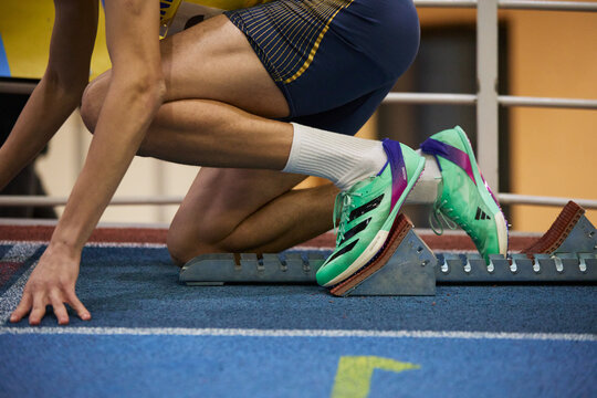 Athlete on a track. Sprinter prepares to run a distance wearing modern Adidas Ultraboost sport shoes. Kyiv - 12 January, 2024