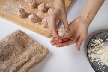 Women's hands make meatballs. Meatballs close-up. Home cooking