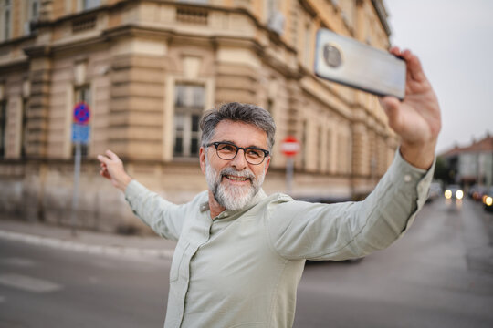 senior man walk on the street and talk on video call on cellphone