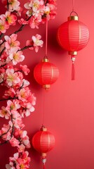 Red hanging paper lanterns with a branch full of tiny colorful flowers next to it. Chinese New Year theme with red background and copy space.