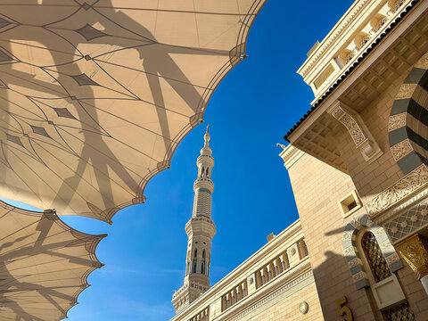 Al-Masjid an-Nabawi (Prophet's Mosque) in Medina city, Saudi Arabia against the background of blue clear sky with place for text. Islamic background for Eid al Fitr Eid al Adha.