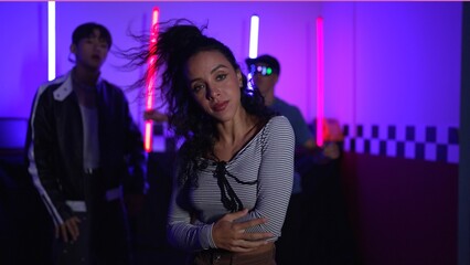 Skilled break dancer dancing in front of camera while diverse friend moving to pop or hip hop music...
