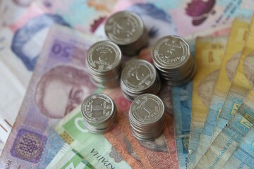 Few stacks of ukrainian money coins lies on old hryvnia banknotes