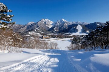 A breathtaking view of towering snow-capped mountains, glistening under a clear blue sky, highlighting the serene beauty of nature in a winter landscape.