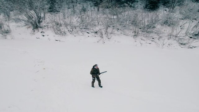 The hunter saw the prey and begins to hunt down the prey recklessly. He takes aim at the game. A double-barreled smoothbore rifle. Aerial photography.