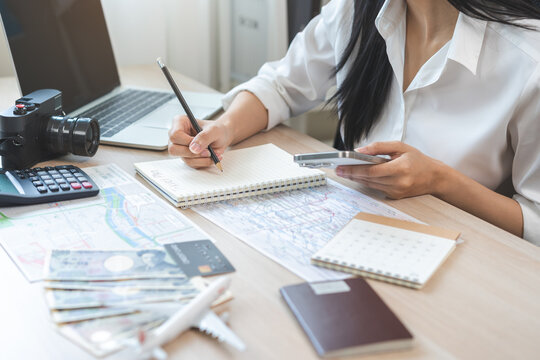 Travel planning, vacation, holiday trip concept, asian young tourist woman hand take note, check list using mobile phone searching information booking hotel online, ticket preparation for journey trip