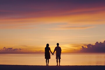 Fototapeta premium Couple holding hands on a beach with their silhouettes glowing against a dramatic sunset symbolizing connection and love