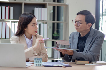 Fototapeta premium A real estate business woman and man sign a house contract and explain their housing project.