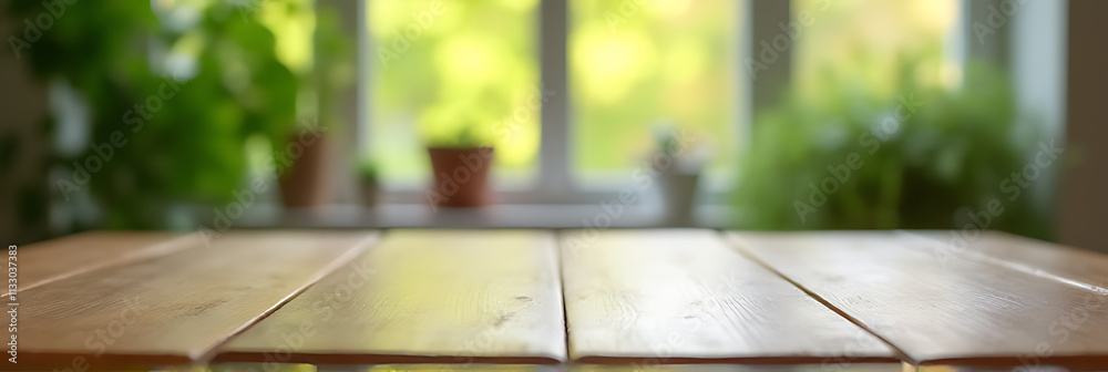 Poster an empty wooden tabletop is reflected in a blurred green garden scene from the kitchen window in the
