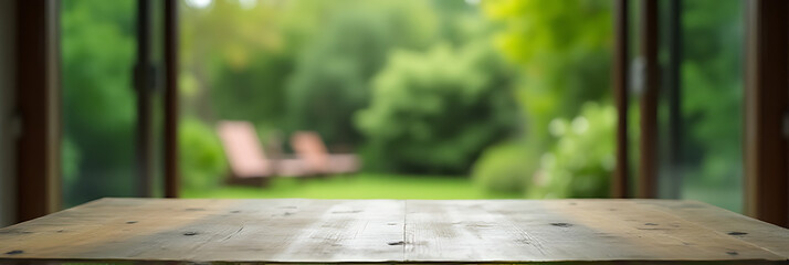 Naklejka premium A worn wooden table in a blurred green hue blends seamlessly into the adjacent garden from the living room._00001_