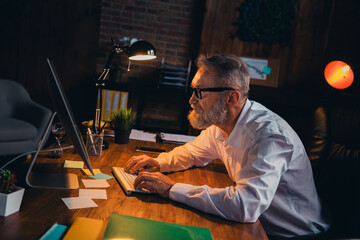 Photo of nice old man working nigh shift tired wear white shirt formalwear coworking evening light...