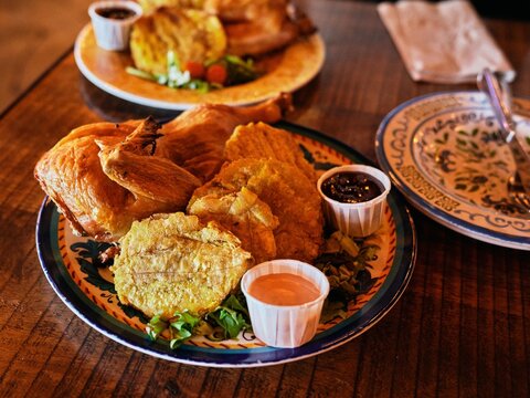 Roasted chicken with fried plantains food plats on metal table