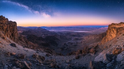 Naklejka premium A panoramic view of a mountainous landscape at dusk, showcasing vibrant color and stars.