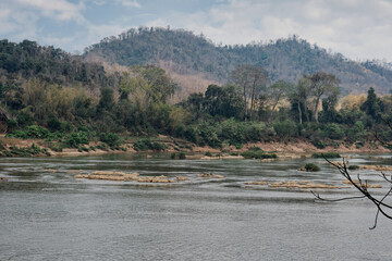 Rapids in the Mekong river, Luang Prabang, Laos, with the mountains and trees are in the background.