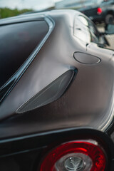 Fototapeta premium Close-Up of a Sleek Modern Car Rear Panel with Red Tail Light Highlighting Sporty Design