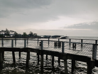 Beach view with cloudy weather on the edge of the pier. Bad weather concept at sea