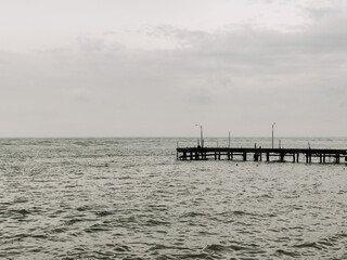 Beach view with cloudy weather on the edge of the pier. Bad weather concept at sea